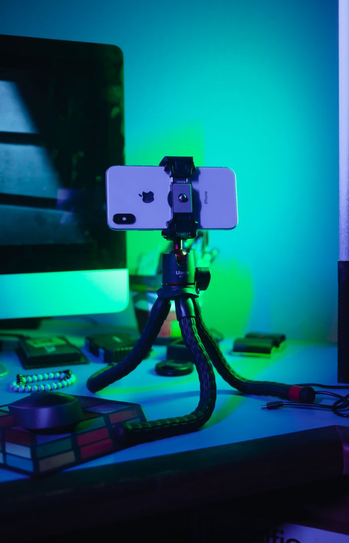 Crafting Captivating Headlines: Your awesome post title goes here Close-up of a smartphone on a flexible tripod in a tech-savvy workspace.
