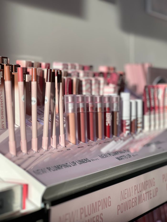 Vibrant display of lip liners and gloss in a retail store, showcasing diverse colors.